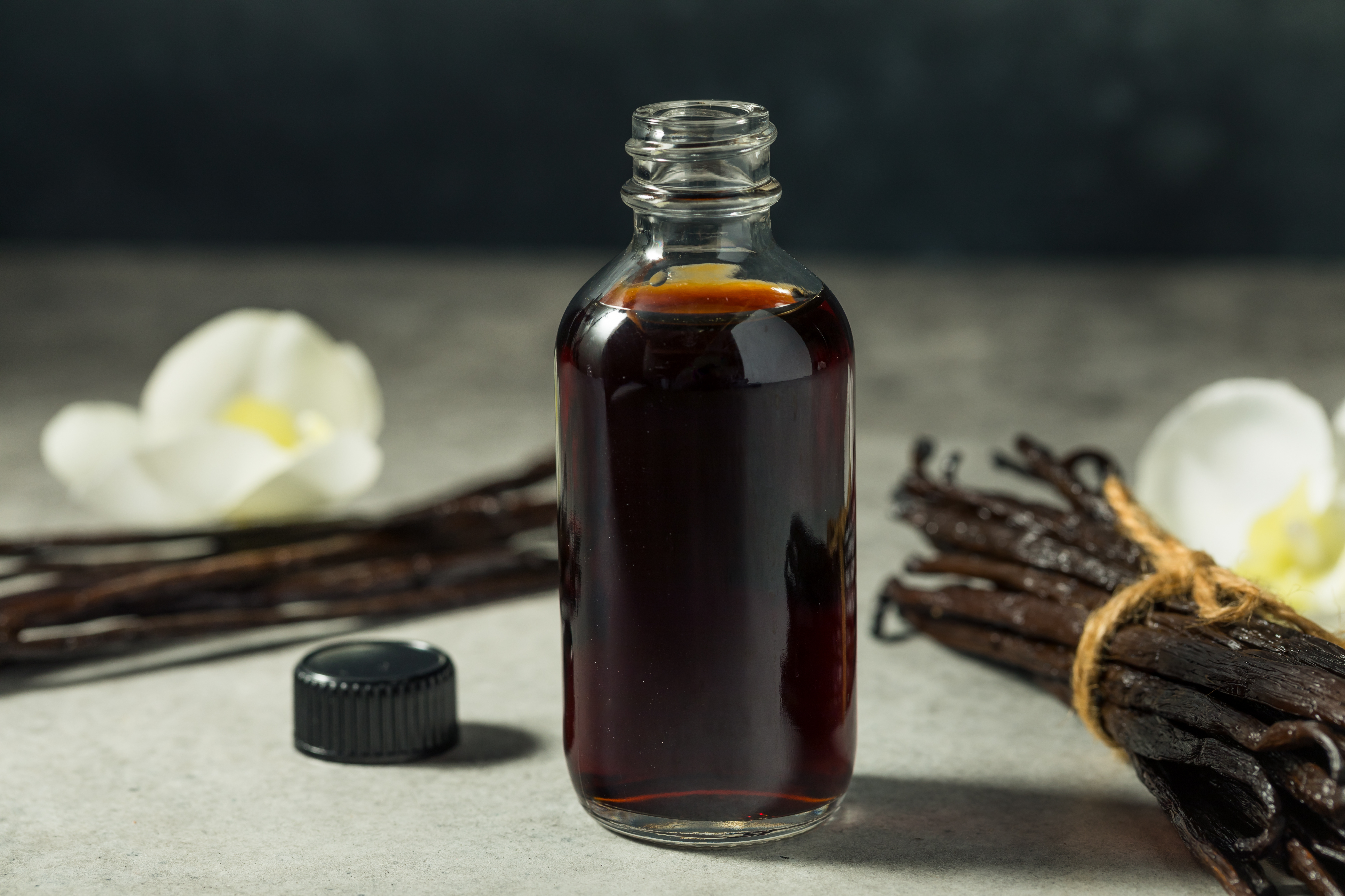 dark vanilla extract in a glass bottle with vanilla beans
